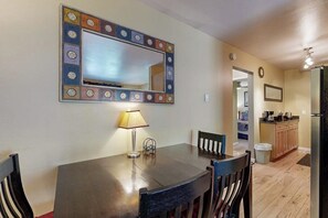 Un comedor con una mesa, sillas, una lámpara y un espejo decorativo.