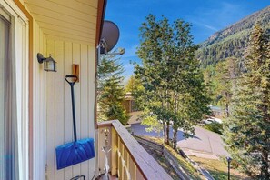 Un balcone con un'antenna parabolica, una scopa e un tappetino blu.