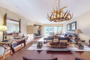 Ein geräumiges Wohnzimmer mit Essbereich, Kamin und einer großen Kronleuchter.