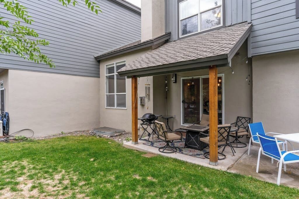 A patio with outdoor furniture, a grill, and a covered seating area.