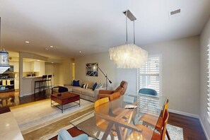 Ein modernes Wohnzimmer mit einem Glastisch, einer Couch und einer Pendelleuchte.