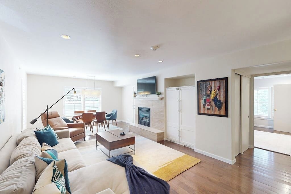 A spacious living room with a sofa, coffee table, and fireplace.