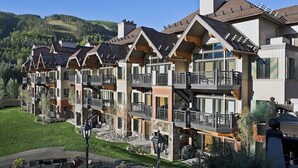 A multi-story hotel with balconies, a stone facade, and a view of the surrounding landscape. - Ski-in/out Lionshead retreat w/ fireplace, fast WiFi, W/D & shared pool/hot tubs (Vail)