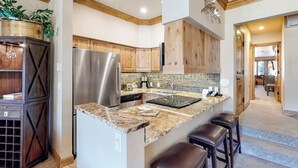 Una cucina moderna con isola centrale, elettrodomestici in acciaio inossidabile, mobili in legno e forno integrato.