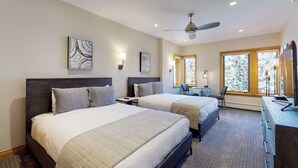 Een hotelkamer met twee bedden, een bureau, een stoel en een televisie.