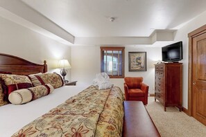 A bedroom with a bed, a chair, a TV, a dresser, and a window. - Chalet in Ski-In/Ski-Out Complex w/Fireplace, Fast WiFi, & Shared Pool/Hot Tubs (Vail)