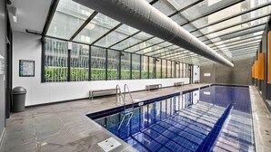 Ein beheizter Innenpool mit Glasdecke, einer Sitzbank und einem Schild an der Wand.
