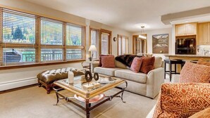 Una sala de estar con sofá, una mesa de centro y una ventana con persianas.