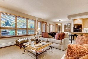 Ein Wohnzimmer mit einer Couch, einem Couchtisch und einem Fenster mit Jalousien.