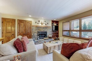 Ein Wohnzimmer mit Kamin, Holztüren, einer Couch und einem Couchtisch.
