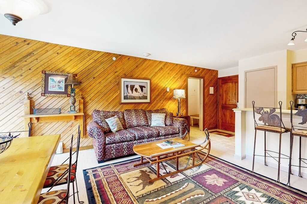 A cozy living room with a patterned sofa, a wooden coffee table, and a rug.