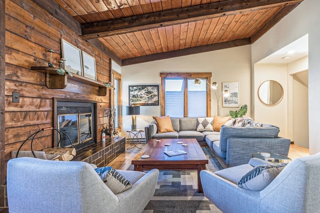 A cozy living room with a fireplace, sofas, and a coffee table.