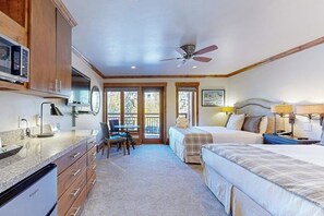 Un dormitorio con dos camas, un escritorio y una silla.