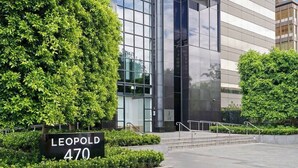Un edificio moderno con un letrero que dice 'LEOPOLD 470', rodeado de follaje cuidado.