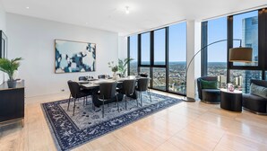 Un salón amplio con comedor, ventanas grandes y vista a la ciudad.