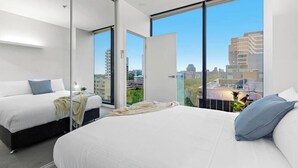 A modern hotel room with two beds, large windows, and a city view. - Charlie - Floor to Ceiling Views Stunner. Parking. (Melbourne)