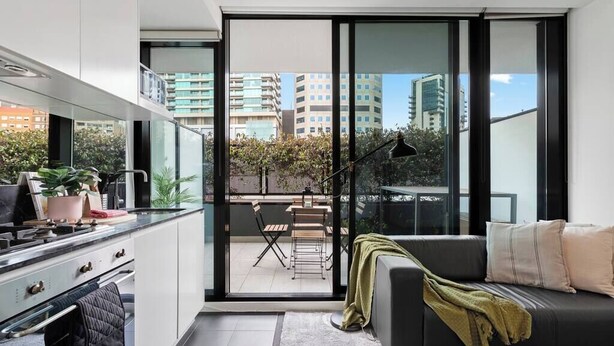 Un apartamento moderno con cocina, comedor y un balcón con vista a la ciudad.