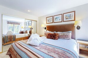 A hotel room with a large bed, a mirror, and three framed pictures on the wall. - Ski-in/out, mountain view condo with fireplace & shared pool, hot tub, laundry (Vail)
