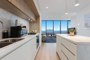 Eine moderne Küche mit Blick auf die Stadt, ein Essbereich mit einer Couch und ein großes Fenster.
