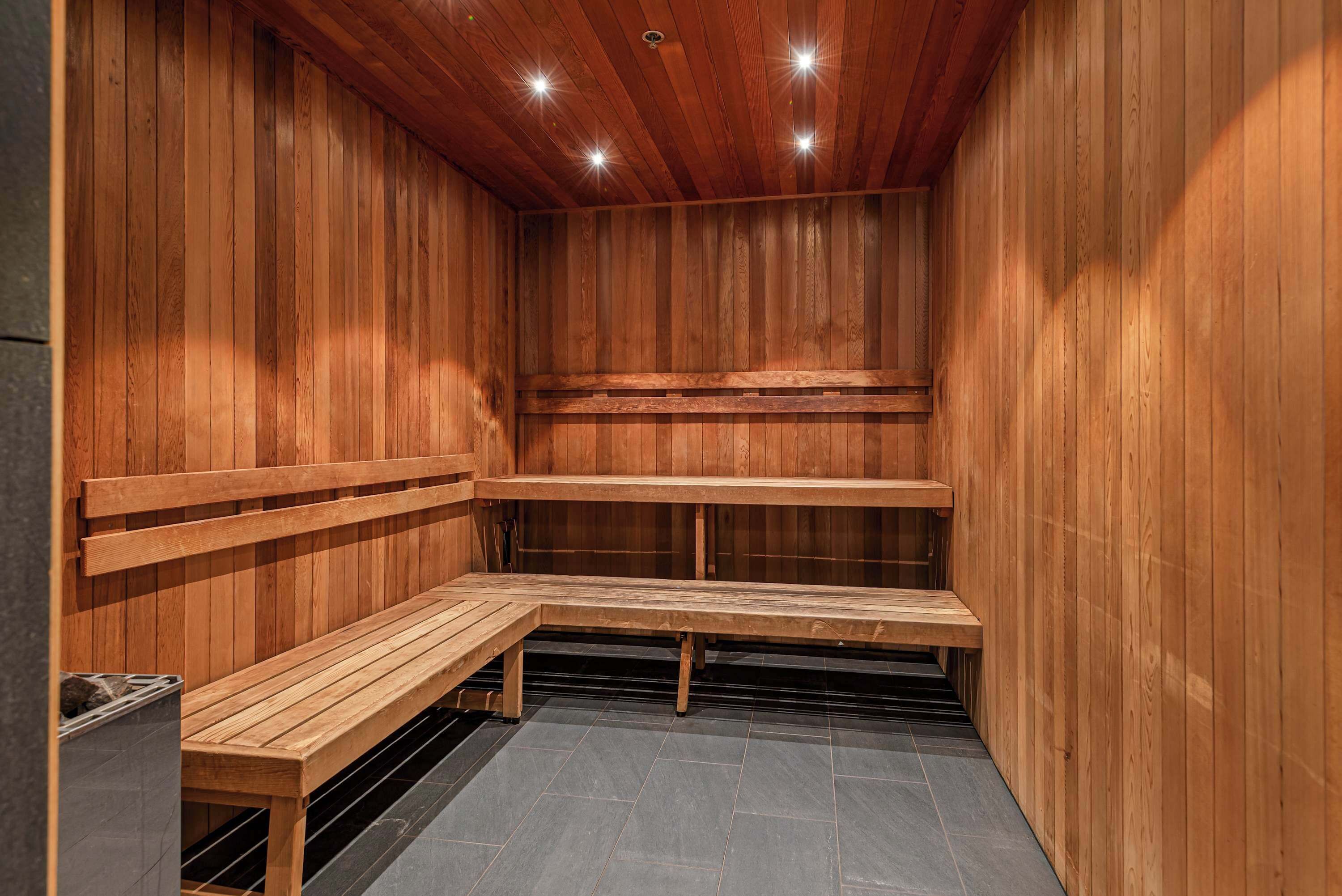 Una sauna con bancos de madera y piso de baldosas.