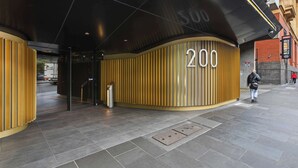 Een hotelgevel met het grote nummer '200', een modern ontwerp met verticale lijnen en een metalen deur.