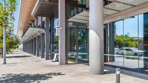 Un bâtiment moderne, reconnaissable à son grand panneau indiquant « P.M. », à ses larges fenêtres en verre et à sa galerie couverte.