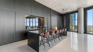 Cozinha moderna com ilha central, banquetas e vista para a cidade.