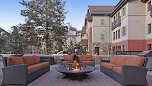 An outdoor seating area with wicker furniture and a central fire feature. - Ski-In/Ski-Out Condo with Fast WiFi plus Shared Pool, Hot Tubs, & Laundry (Vail)