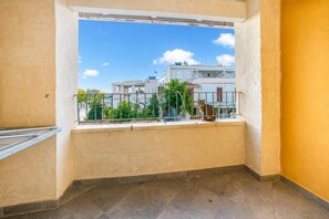 A balcony with a view of buildings, a railing, and a cat. - Pino 2 -3 Bedrooms Near The Sea, Nardò, Italy (Nardò)