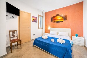 A hotel room with a bed, a chair, a TV, a window, and artwork on the wall. - Pino 2 -3 Bedrooms Near The Sea, Nardò, Italy (Nardò)