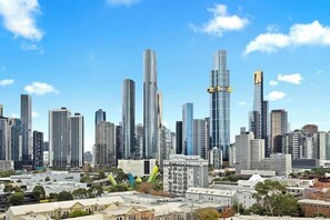 Eine Stadtansicht mit modernen Wolkenkratzern, einer Mischung aus Hochhäusern und Gebäuden mittlerer Höhe, und blauem Himmel.