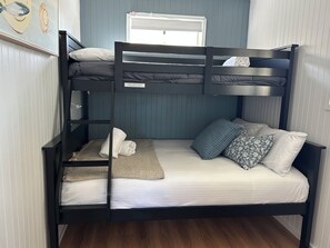 A bunk bed with a window above, a towel on the lower bunk, and a pillow on the upper bunk. - Yerriyong 2 - Family Cabin Sleeps 6 Mollymook (Mollymook)
