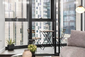 A modern balcony with a view of high-rise buildings, a small table, and two chairs. - Riley - Resort Living * Gym Sauna Pool Wi-Fi (Southbank)
