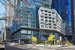 Ein modernes Gebäude mit einem markanten, winkelförmigen Design, mehreren Stockwerken und einer Glasfassade.
