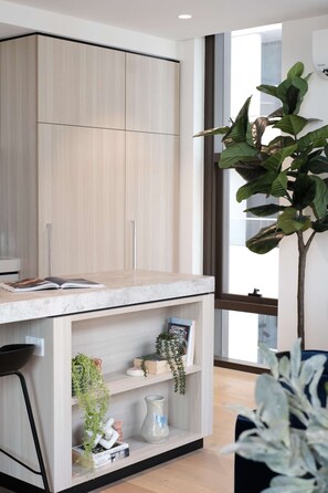 A modern room with a built-in desk, shelves, and a large window. - Southbank stunner with parking views gym and pool! (South Melbourne)
