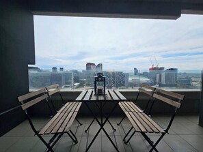 Ein Balkon mit Tisch und Bänken, der einen Blick auf die Stadt erlaubt.