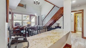 Ein Wohnzimmer mit Kamin, einer Treppe und einem Essbereich mit Marmorplatte.