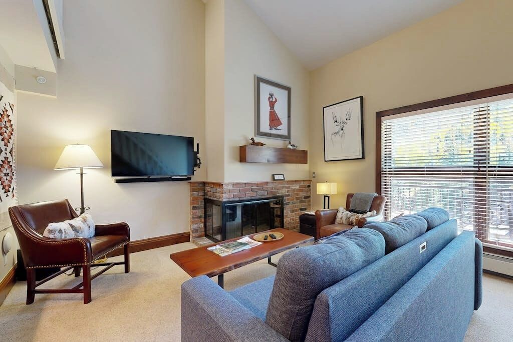 A living room with a fireplace, a television, and a sofa.