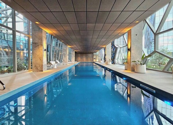 A long indoor swimming pool with clear glass walls and a modern design. - Xia -Jaw-dropping 3BD2BTH Executive City Residence (Melbourne)