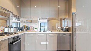 A modern kitchen with stainless steel appliances, a dishwasher, and a large island with a sink. - Resort-style 3bed2bath Executive Southbank Pad (Southbank)