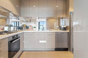 A modern kitchen with stainless steel appliances, a dishwasher, and a large island with a sink. - Resort-style 3bed2bath Executive Southbank Pad (Southbank)