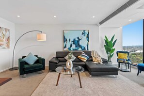 A modern living room with a sofa, a glass coffee table, a floor lamp, and a large abstract painting. - Resort-style 3bed2bath Executive Southbank Pad (Southbank)
