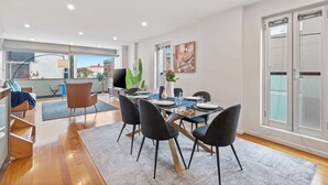 Ein modernes Esszimmer mit einem Glastisch, schwarzen Stühlen und Blick auf die Stadt.