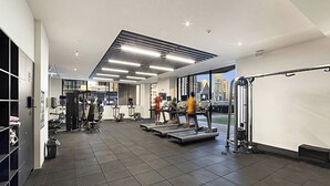Een sportschool met loopbanden, gewichtstoestellen en uitzicht over de stad.