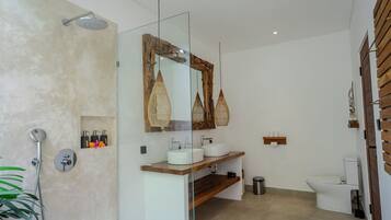 Une salle de bain moderne avec une douche à parois de verre, un meuble-lavabo en bois, des toilettes blanches et un grand miroir.