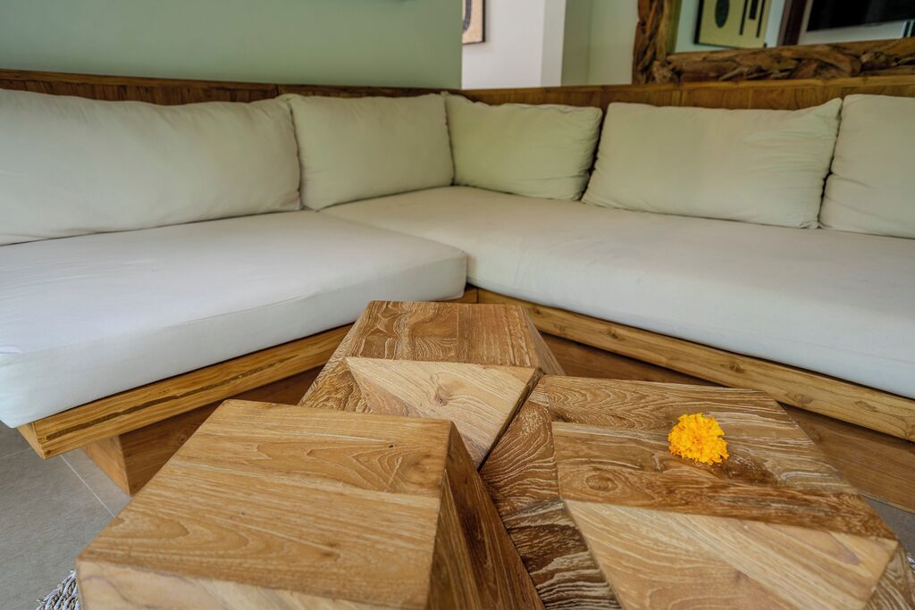 A modern living room with a sectional sofa and three wooden coffee tables.
