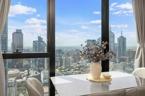 Blick auf die Stadt von einem Hochhaus aus, mit Tisch und Blumenvase.
