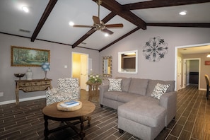 A living room with a gray sofa, wooden coffee table, and a ceiling fan.