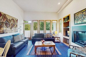 Ein Wohnzimmer mit Sofa, Couchtisch und Kunstwerken an den Wänden.