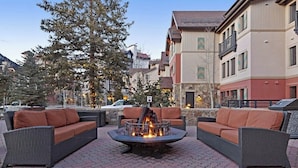 Eine Terrasse mit Korbmöbeln und einem zentralen Feuerkorb.